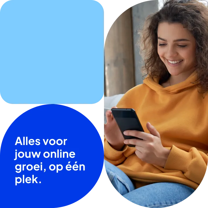 Glimlachende jonge vrouw met krullend haar in een oranje hoodie kijkt naar haar telefoon.