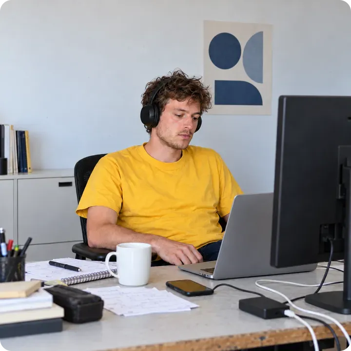 Beeldscherm vol code, naast een glimlachende man met een Hostnet-koffiemok.